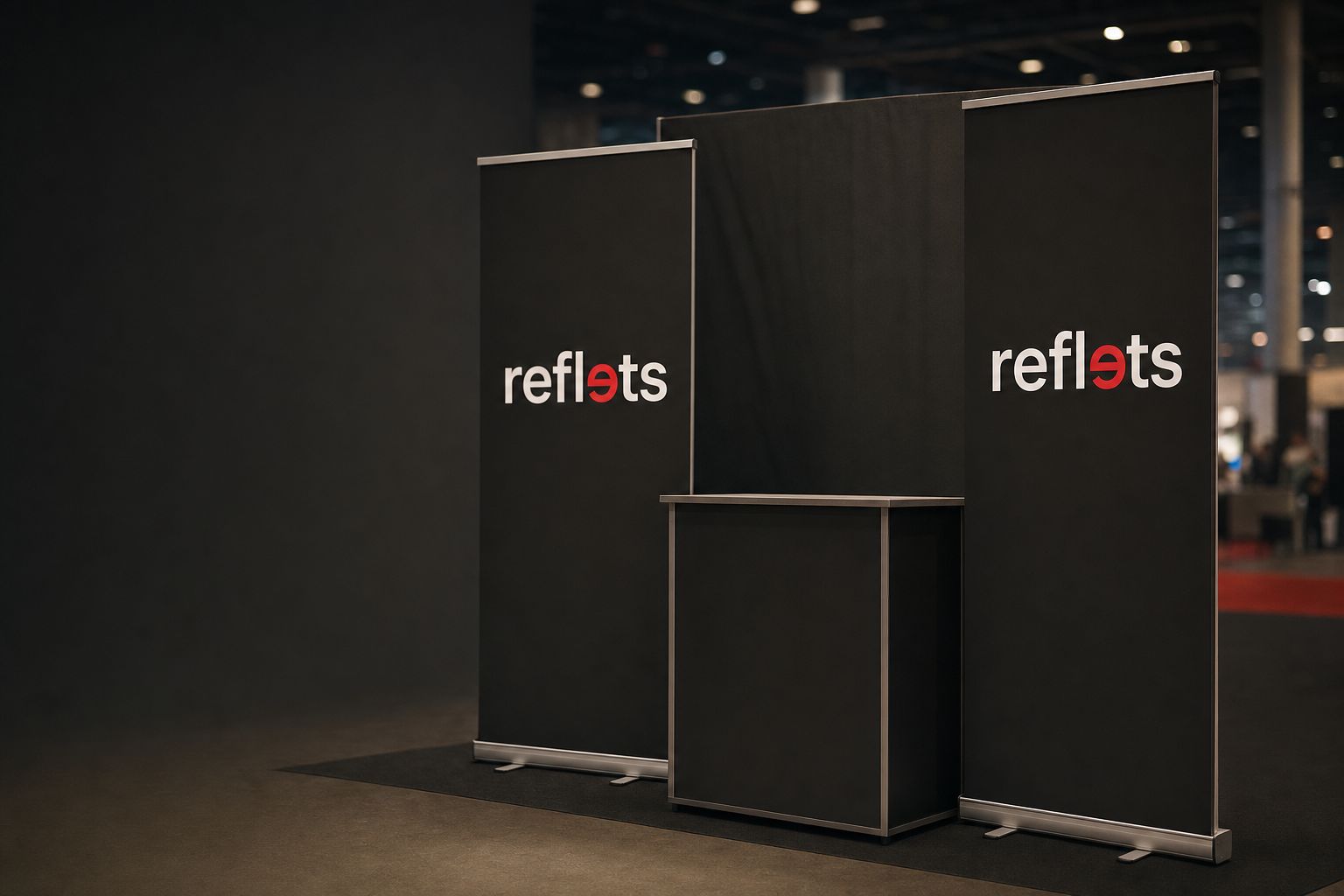 Stand de salon avec deux roll-ups noirs sur cassette aluminium portant le logo Reflets de part et d'autre d'un comptoir, mur de fond en tissu, lumières du hall floues